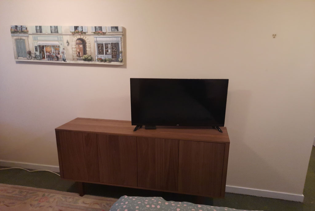 On top of the walnut veneer Ikea sideboard the customer asked us to place his television. All cables were hidden as good as possible behind and under the sideboard. A flat pack assembly by Flat Pack Happy.