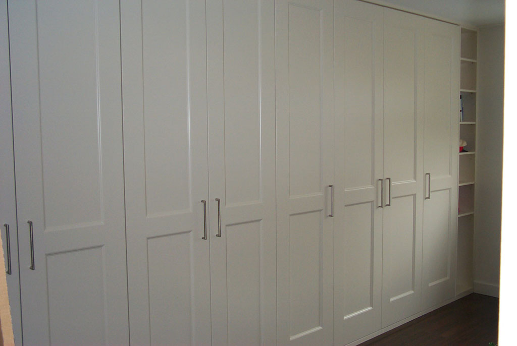 A wardrobe with 8 doors and an open storage bit with multiple shelves. Assembled by Flat Pack Happy.